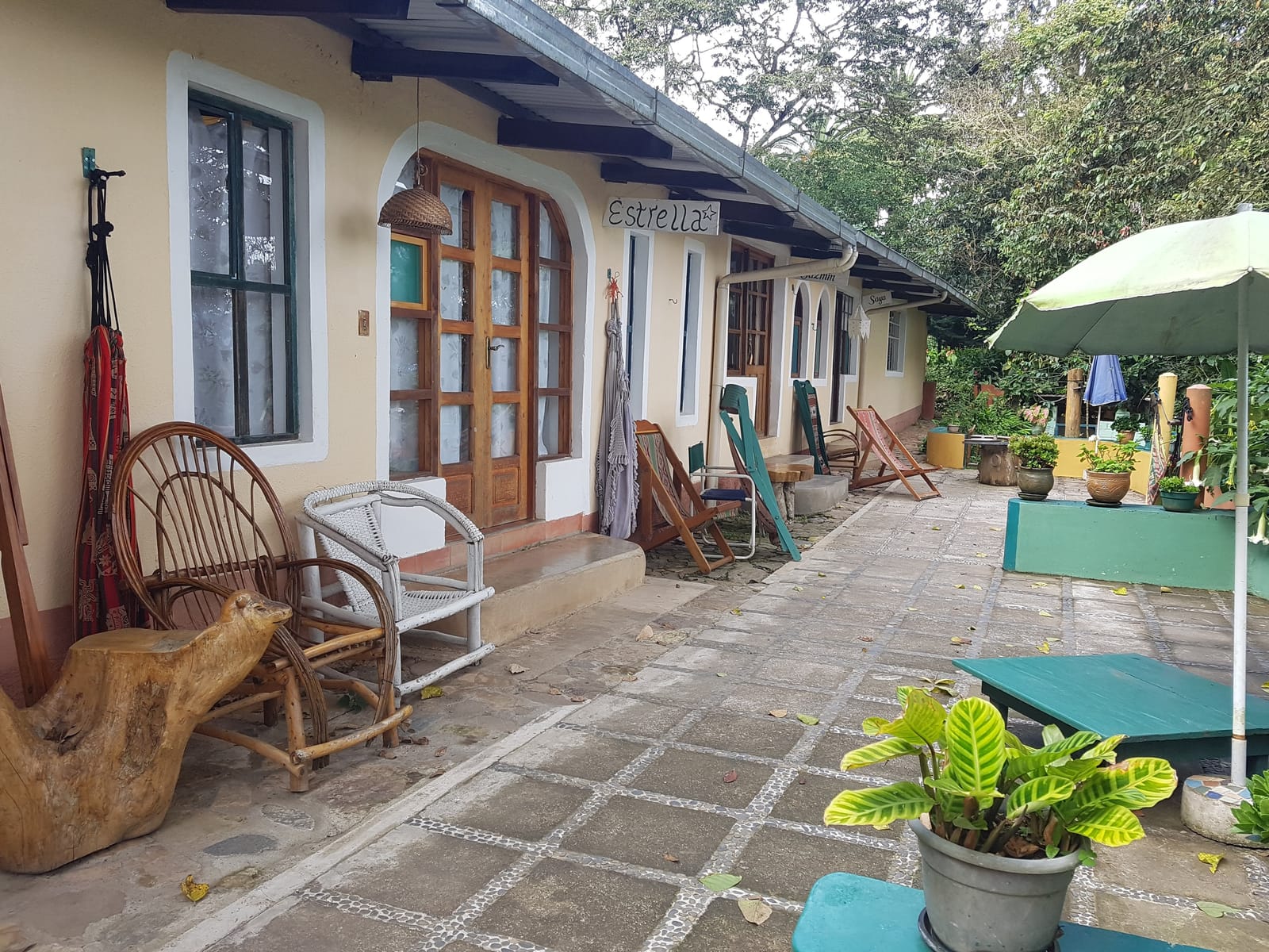 Terraza con hamacas y sillas frente a las habitaciones del hostal
